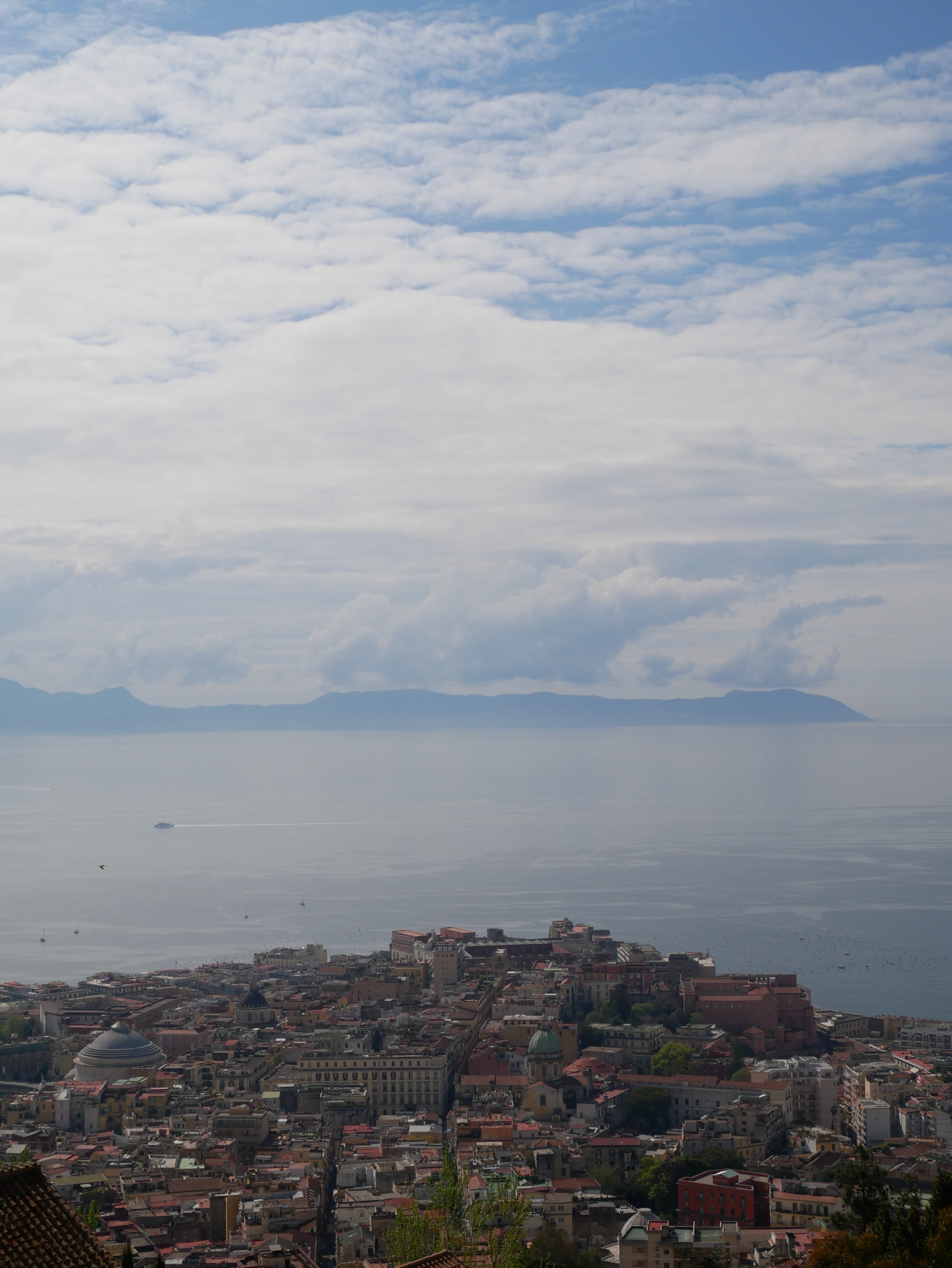 Person standing on a rocky limestone plateau above the sea